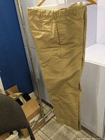Tan cotton working pants size 32L hanging showing side pockets and belt loops