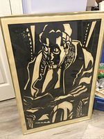 Full view of framed papercut artwork showing the seated Jewish scholar in black and white with signature 'WL'.