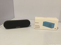 Black wireless speaker with rounded edges on white surface, speaker appears compact, likely Sony brand.