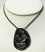 Photo of the sterling silver necklace displayed on a stand showing the full chain and pendant.