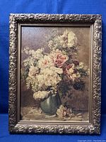 Front view of the ornately carved gold-tone frame surrounding the floral textured print