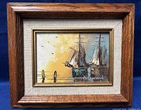 Framed oil on board painting depicting two sailing ships at sunset with Bernard signature.