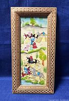 Full view of framed Persian art painting showing traditional scene with people, horses, and tents.