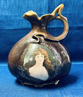 Front view of Jungfrau Porzellan pitcher showing the hand painted portrait and handle design.
