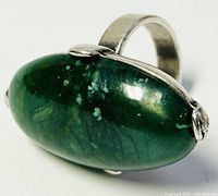 Close-up angled view of the silver ring showing green oval serpentine stone in bezel setting