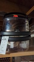 Photo of clear plastic cold circulation system with black handle and 'ICE' lettering visible, stored on a shelf.