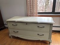 Lane cedar chest with two large drawers, visible handles, cream color, positioned in a room with window and curtains