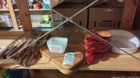 Photo showing wooden boards, small Pyrex Gooseberry dish, red onion soup bowls stacked, and white pie dish