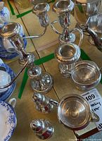 Overview of two candelabras alongside sugar bowl, creamer, salt and pepper shakers