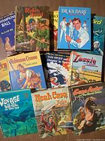 Photo showing the front covers of multiple vintage children's books including Robin Hood, Dr. Kildare, Robinson Crusoe, Tom Swift Jr., Lassie, Gene Autry, among others.
