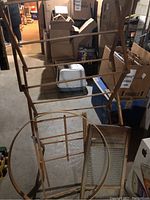 Photo showing two wooden drying racks, one large and one smaller, an embroidery hoop resting against the racks, and a wooden washboard beside them on the floor.