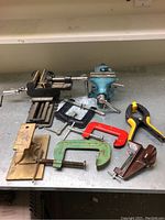 Overview photo showing full range of assorted clamps and the small anvil on a tabletop.
