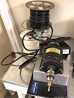 Overview of coil winder, foot control, and wire spools on tabletop