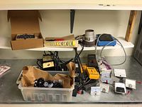 Workbench overview showing multimeter, panel meters, connector block, plastic bin of connectors, pliers
