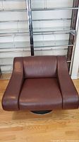 Front view of brown leather swivel armchair with visible armrests and seat cushion
