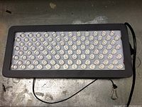 Front view showing grid of LED diodes and attached power cord.