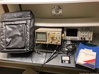 Overall lot: Kikusui COS-5100 analog oscilloscope, Tektronix TDS3012, black carrying case, cables, floppy disk and manuals