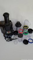 Magic Bullet Juice Bullet juicer and original blender with assorted cups and lids laid out