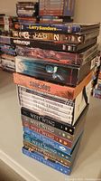 Stack of DVD sets featuring various TV series including The West Wing, Sopranos, 24, Entourage, JAG, and Larry Sanders Show