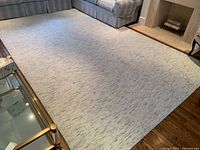 Full view of ivory rug under sectional sofa showing overall size and placement