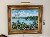 Full front view of framed painting with picture light mounted above