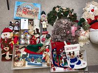 Full view of assorted Christmas decorations, including wooden nutcracker, Avon crystal tree, twisty ornaments, stuffed snowman Santa, wreaths, and stockings.