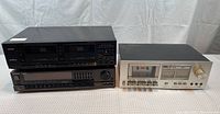 Photo of three stereo equipment pieces stacked together: Teac dual cassette deck on top of Technics receiver, with a Pioneer cassette deck on the right side.