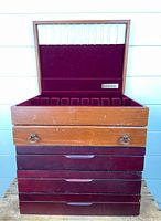 Front view of the four stacked wooden silverware boxes showing drawer and handles