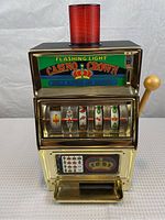 Front view of Casino Crown slot machine showing reels, handle, and flashing light on top.