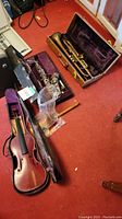 Alto saxophone, trumpet and violin cases on floor