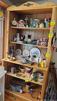 Full view of shelving unit filled with various decorative items, showing number tags on shelves.