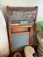 Photo showing two washboards, one large metal washboard by National Washboard Co., and a smaller wooden-framed washboard with metal scrubbing surface, along with other items partially visible.