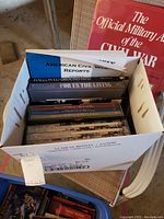 Box containing multiple Civil War history books and reports including American Civil War Reports, Hallowed Ground, For Us The Living, and others.