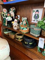 Wooden shelving displaying green-themed Caroler dolls, baskets and decor