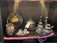 Full lot of handmade pottery displayed on shelf