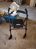 Front view of the Carex wheeled walker showing four wheels, padded seat, and frame detail.