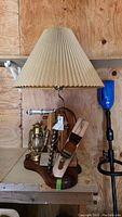 Front view of the nightwatch lamp with wooden base, attached tools, Dietz lantern and pleated fabric shade