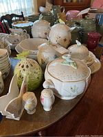 Full display of Lenox Butterfly Meadow pieces on table showing canisters, serving bowls, salt and pepper shakers, napkin holder and soup tureen.