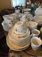 Overall view of stacked dinner plates, mugs and bowls on dining table