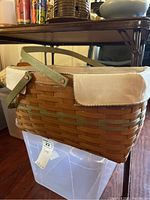 Large woven market basket with cream fabric lining hanging on edge of table