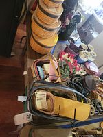 Photo showing rectangular folding table with wooden surface, scratched and worn. Table holding various items not included.