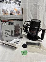 Black & Decker router in black with original box and instruction manual, accessories laid out in front.
