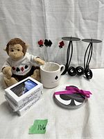 Full lot view showing stuffed monkey, packs of playing cards, card suit drink stir sticks in a mug, candle holders, and coasters.