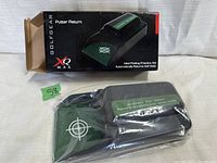 Golf putter return device in original box and plastic wrap, showing branding and labeling