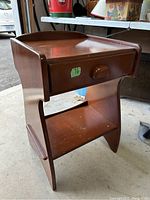 Front view of the midcentury modern solid wood side table showing the drawer and lower shelf.