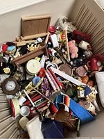 Photo of a box filled with varied miniature items including furniture, kitchenware, and toys