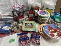 Various unopened paper party supplies showing napkins and plates for different occasions including holiday themes, and plastic cups.