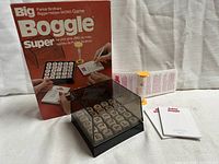 Photo showing full set including black plastic grid with letter blocks, sand timer, paper pads, instruction booklet, and original vintage box