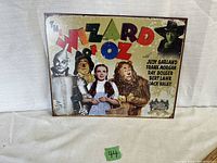 Front view of The Wizard of Oz metal poster showing colorful art and cast credits.