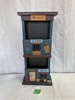 Front view of wooden mail sorter shaped like post office with MAIL and BILLS compartments